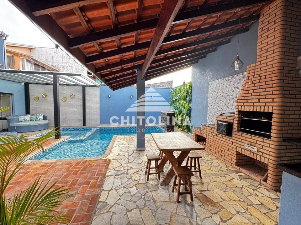 Churrasqueira em tijolinho com mesa de madeira junto à piscina — Casa cód. 9584, Jardim Colombo